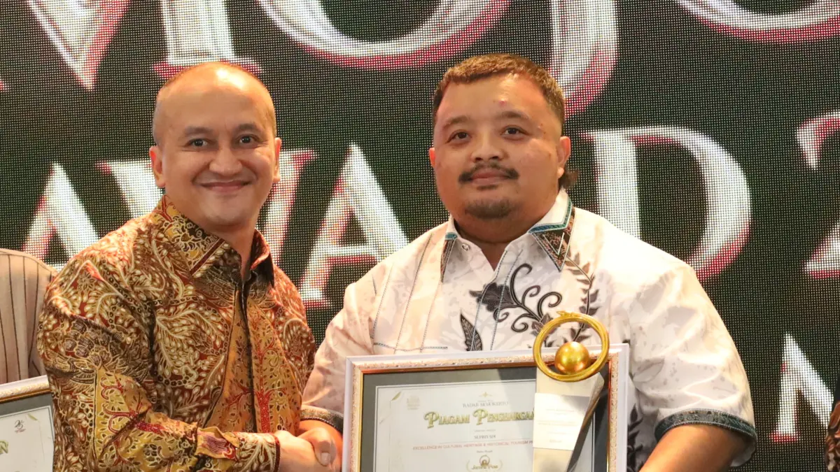 BUKTI KEPERCAYAAN: M. Fuad Arisuddin, pendiri Athariz Building menerima penghargaan Jawa Pos Radar Mojokerto Award 2026 yang diserahkan Danrem 082/CPYJ Kolonel Inf. Batara saat malam penghargaan yang digelar di Ballroom Sunrise Hotel Mojokerto, Kota Mojokerto, pada Selasa (7/7). (Anggi Fridianto JPRJ)