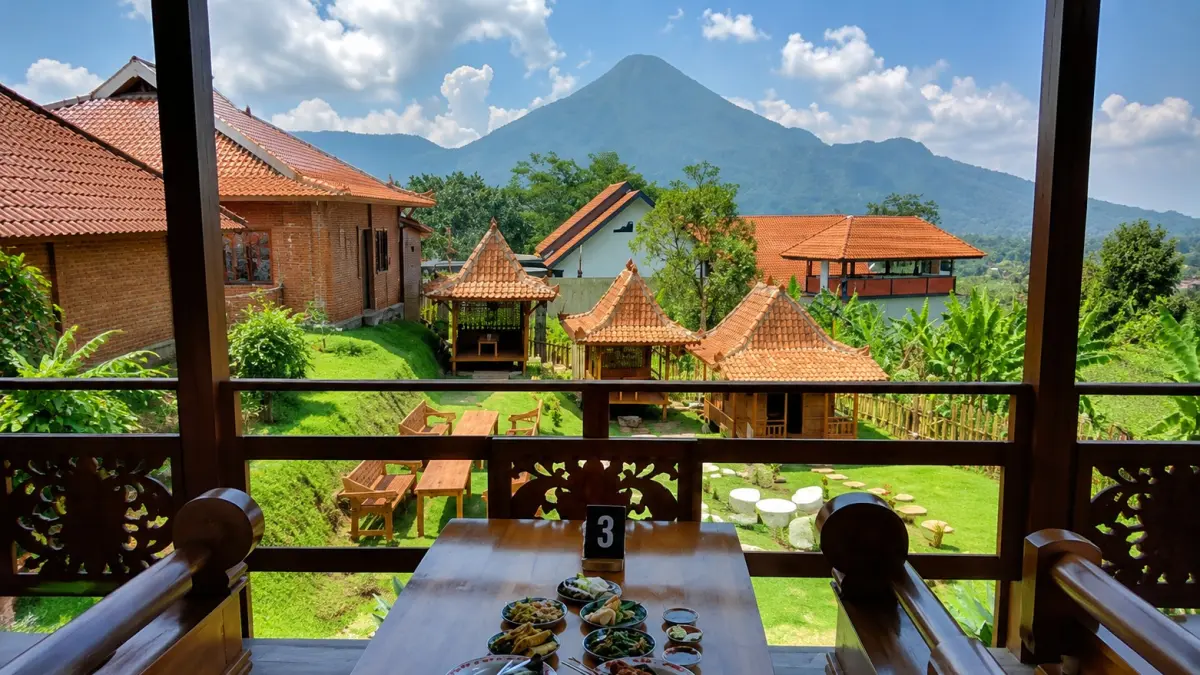 Hidangan khas Nusantara tersaji di atas meja kayu dengan latar Gunung Penanggungan. Dari Gazebo Pawon Djadoel Tamiajeng, pengunjung dapat menikmati suasana pedesaan yang asri, bangunan bergaya joglo, dan udara sejuk khas Trawas.
