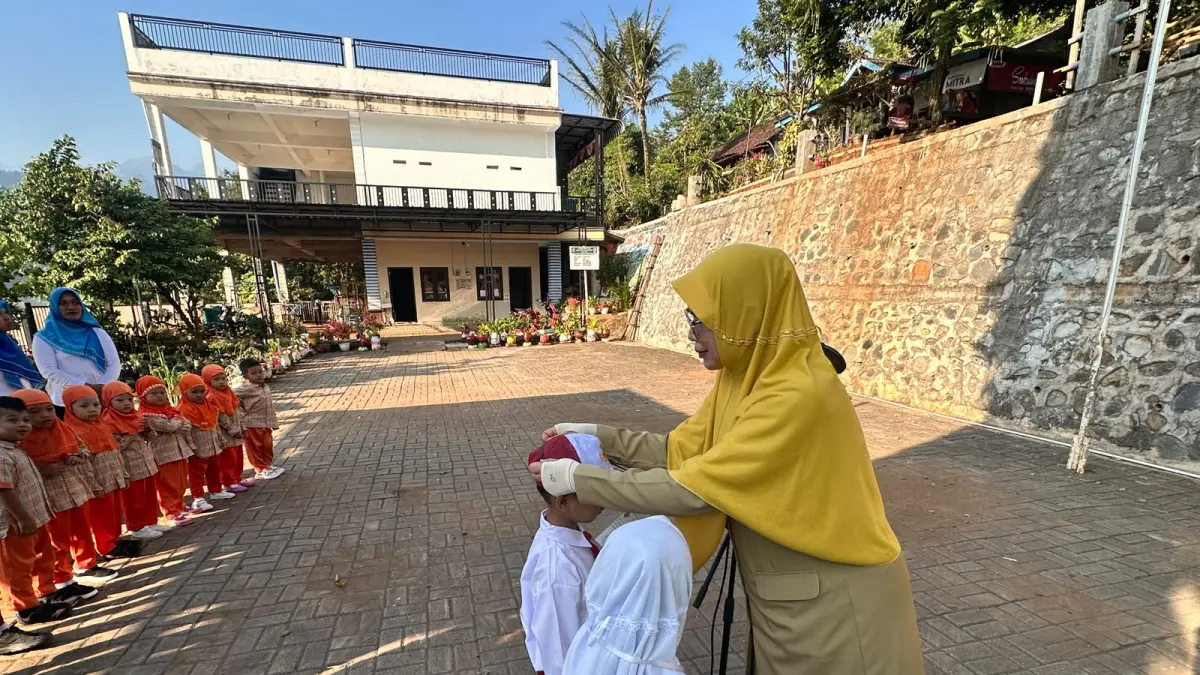 KEKELUARGAAN: Kepala Sekolah SDN Dilem Uswatun Khasanah menyematkan tanda pengenal kepada siswa baru.