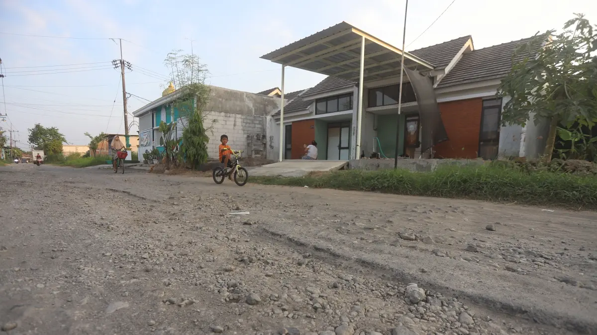TAK TERAWAT: Ruas jalan di Perumnas Jetis mengalami kerusak parah, kemarin (19/7). Selama musim hujan, ruas jalan ini menggenang dan luapan air hingga ke permukiman warga. Selama musim kemarau debu beterbangan di kawasan perumahan. (Sofan JPRM)