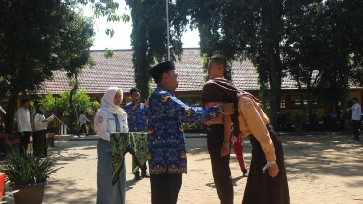 PEMBUKAAN: Kepala SMAN 1 Mojokerto Subandi secara simbolis menyematkan tanda peserta MPLS kepada perwakilan siswa baru. (Indah JPRM)