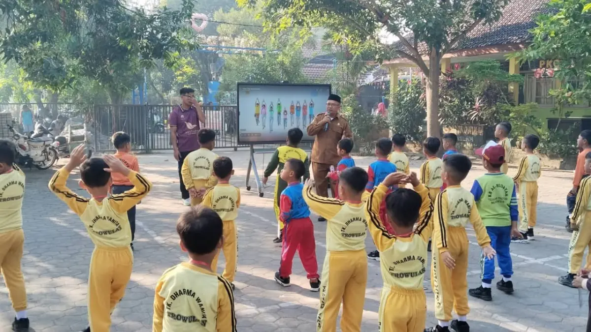 PENYAMBUTAN: Kepala SDN Trowulan Sakuwan menyambut siswa baru saat pembukaan MPLS Ramah 2026.