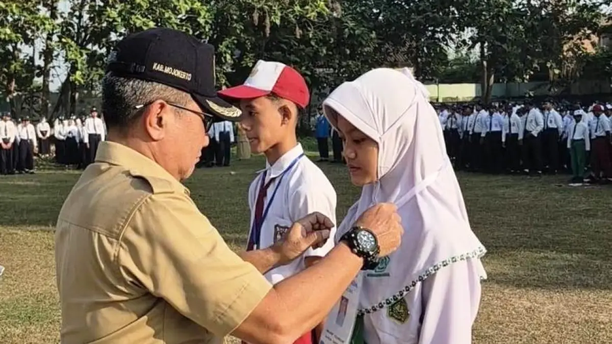 PENYEMATAN: Kepala SMPN 2 Bangsal, Iwan Happy Usmarasima, menyematkan atribut tanda peserta kepada siswa baru di halaman SMPN 2 Bangsal, Senin (13/7).  (Indah JPRM)