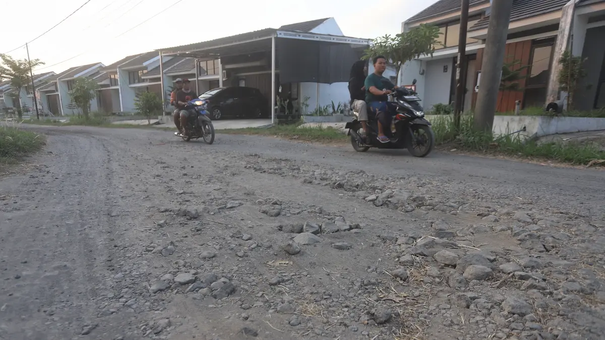 TAK TERAWAT: Ruas jalan di Perumnas Jetis mengalami kerusak parah, Minggu (19/7). Selama musim hujan, ruas jalan ini menggenang dan luapan air hingga ke permukiman warga. Selama musim kemarau debu beterbangan di kawasan perumahan. (Sofan JPRM)