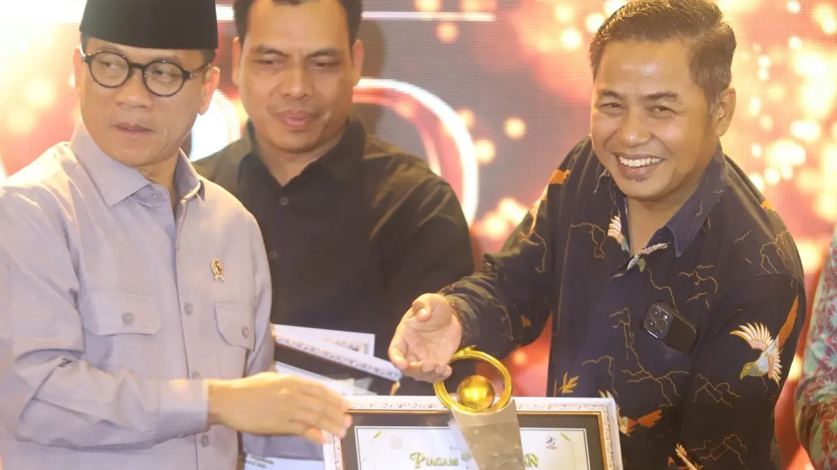 APRESIASI: Mendes PDT Yandri Susanto menyerahkan penghargaan Jawa Pos Radar Mojokerto Award 2026 kategori Pelopor Kolaborasi Penthalix Daerah kepada Kades Pesanggarahan Moh. Afif, di Ballroom Sunrise Hotel Mojokerto, Selasa (7/7). (Sofan JPRM)