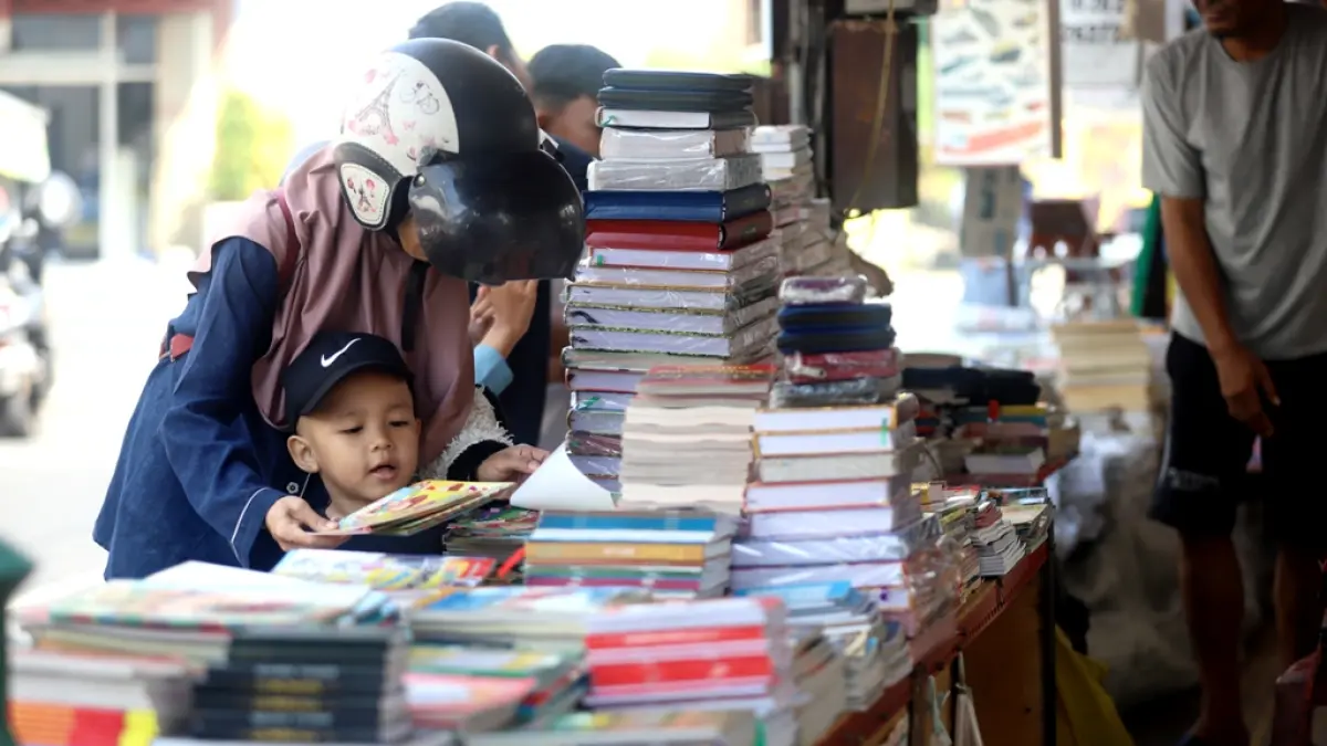 BUKU SEKOLAH: Warga berbelanja perlengkapan sekolah di lapak buku Jalan Niaga, Kelurahan Sentanan, Kecamatan Kranggan, Kota Mojokerto, Minggu (21/7). (Sofan JPRM)