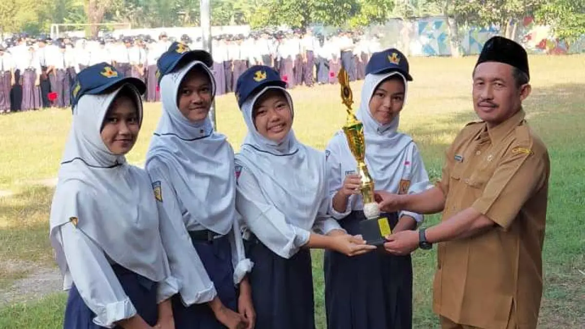 ISTIMEWA: Kepala SMPN 2 Mojosari Abdul Rohman menyerahkan piala kepada perwakilan siswa berprestasi.