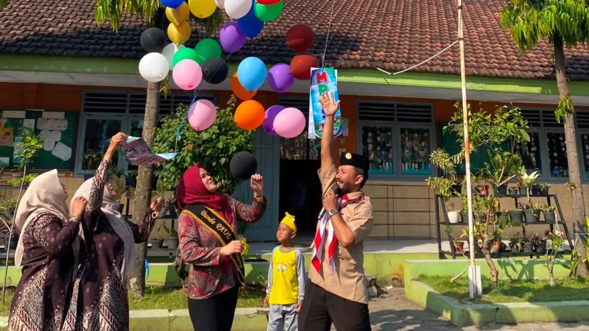 SIMBOLIS: Kepala SDN Mojorejo Lagianto bersama Bunda PAUD Mojorejo, Kecamatan Pungging, Kabupaten Mojokerto menerbangkan balon pada kegiatan MPLS tahun ajaran 2026/2027.