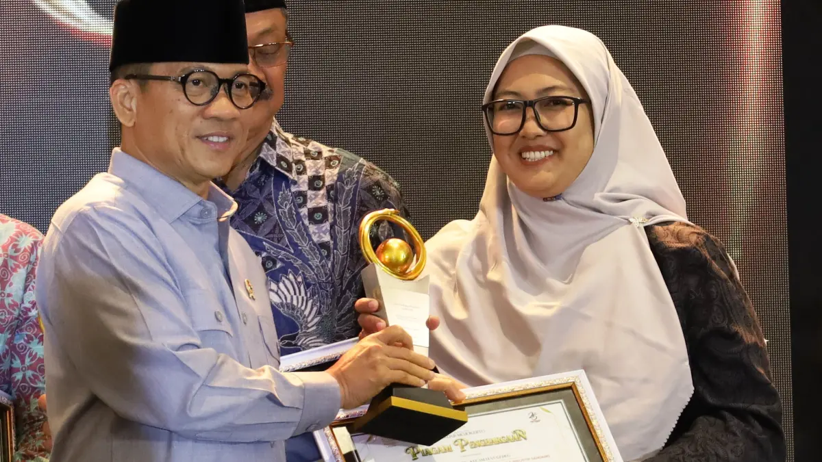 BERKOMPETEN: Sekdes Bandung Nila Retna Mainingsih mewakili Kades Bandung Komari Arifin menerima penghargaan Jawa Pos Radar Mojokerto Award 2026 yang diserahkan langsung oleh Mendes PDT Yandri Susanto, di Ballroom Sunrise Hotel Mojokerto, Selasa (7/7). (Anggi Fridianto/JPRJ)