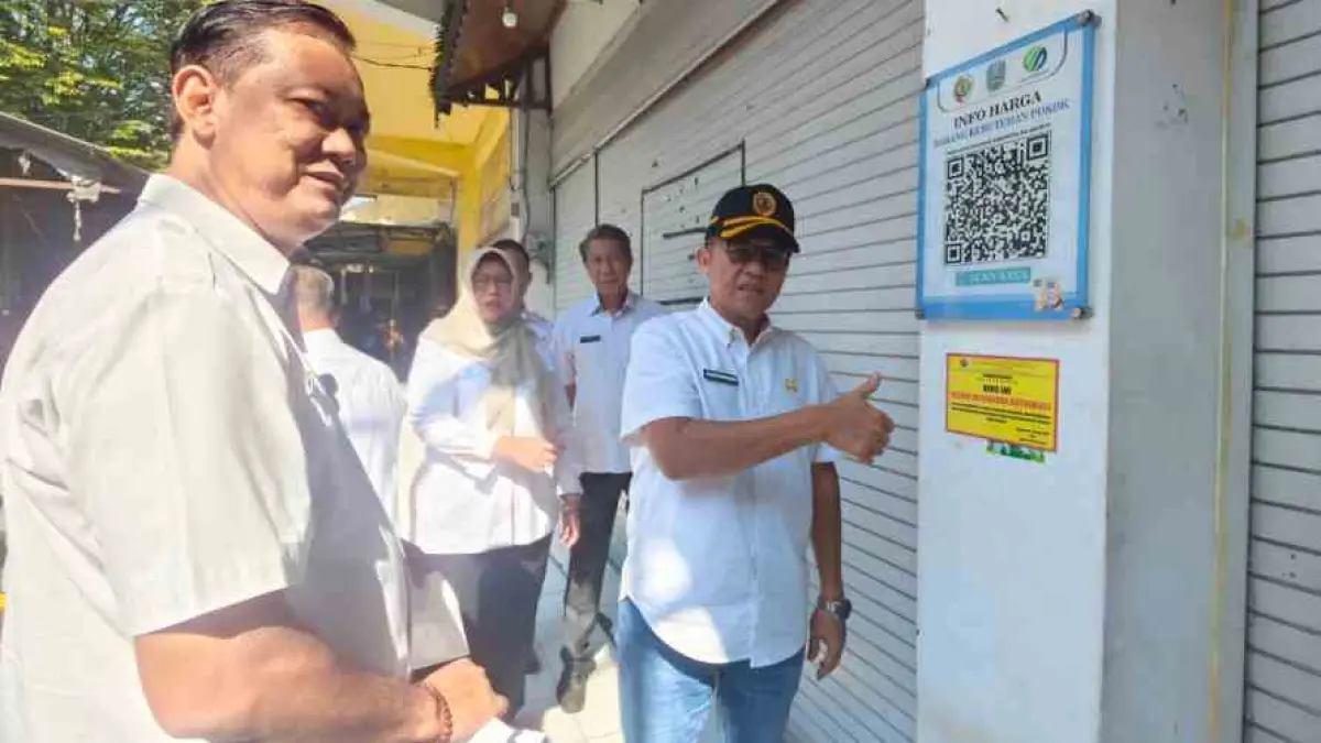 PENERTIBAN: Sekdakab Mojokerto Teguh Gunarko didampingi Kadisperindag Noerhono, Kepala Bapenda Nurul Istiqomah, dan Kepala Diskominfo Nugraha Budhi Sulistya, serta camat setempat menempel stiker himbauan kepada pemilik kios penunggak retribusi di Pasar Raya Mojosari, Rabu (22/7).