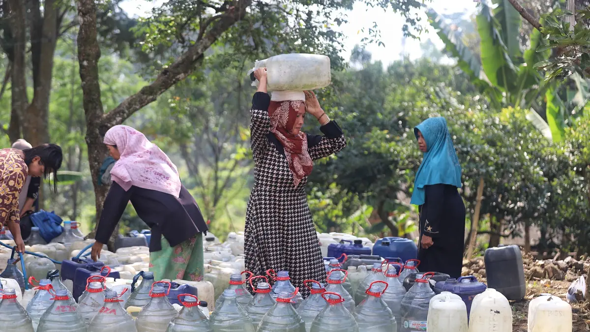DIBUTUHKAN: Warga mengambil air bersih menggunakan jerikan hasil bantuan BPBD Jatim yang di-dropping di Desa Kunjorowesi, Kecamatan Ngoro, Rabu (22/7). (Sofan JPRM)