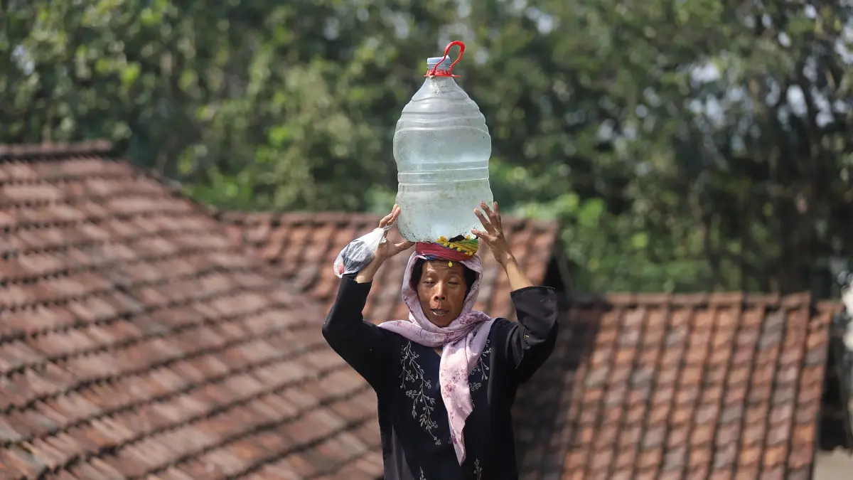 DIBUTUHKAN: Warga mengambil air bersih menggunakan jerikan hasil bantuan Pemkab Mojokerto yang di-dropping melalui BPBD di Desa Kunjorowesi, Kecamatan Ngoro, Rabu (22/7). (Sofan JPRM)