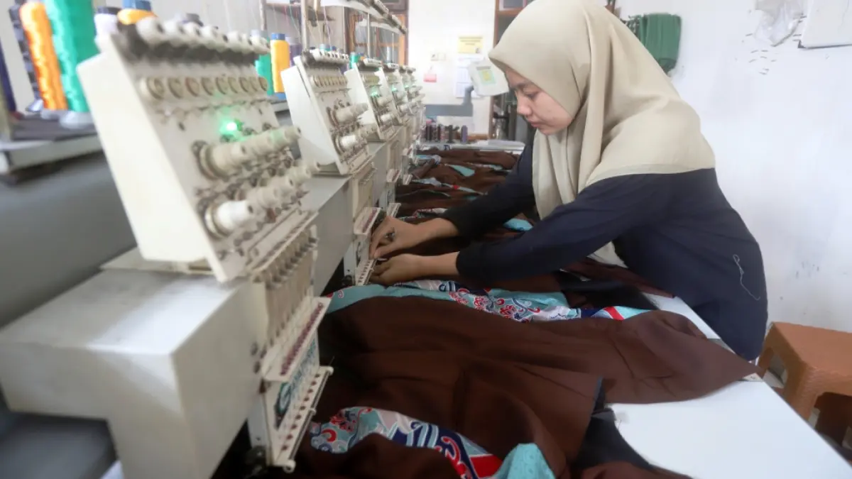 KREATIF DAN KONSISTEN: Pelaku UMKM konfeksi di Desa Bandung mengerjakan pesanan yang datang dari berbagai instansi dan pelanggan luar pulau.