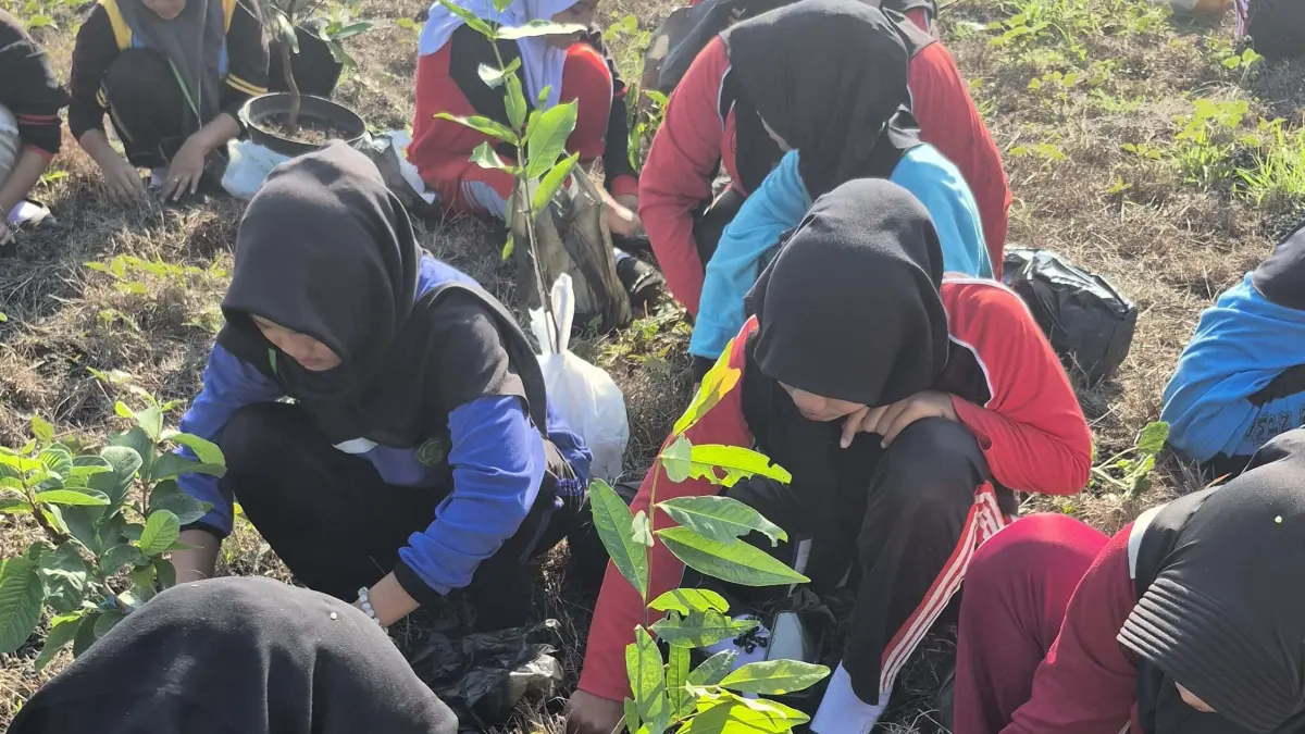 PEDULI LINGKUNGAN: Rangkaian MPLS 2026 diisi dengan kegiatan penanaman pohon oleh siswa baru SMKN 1 Kemlagi.