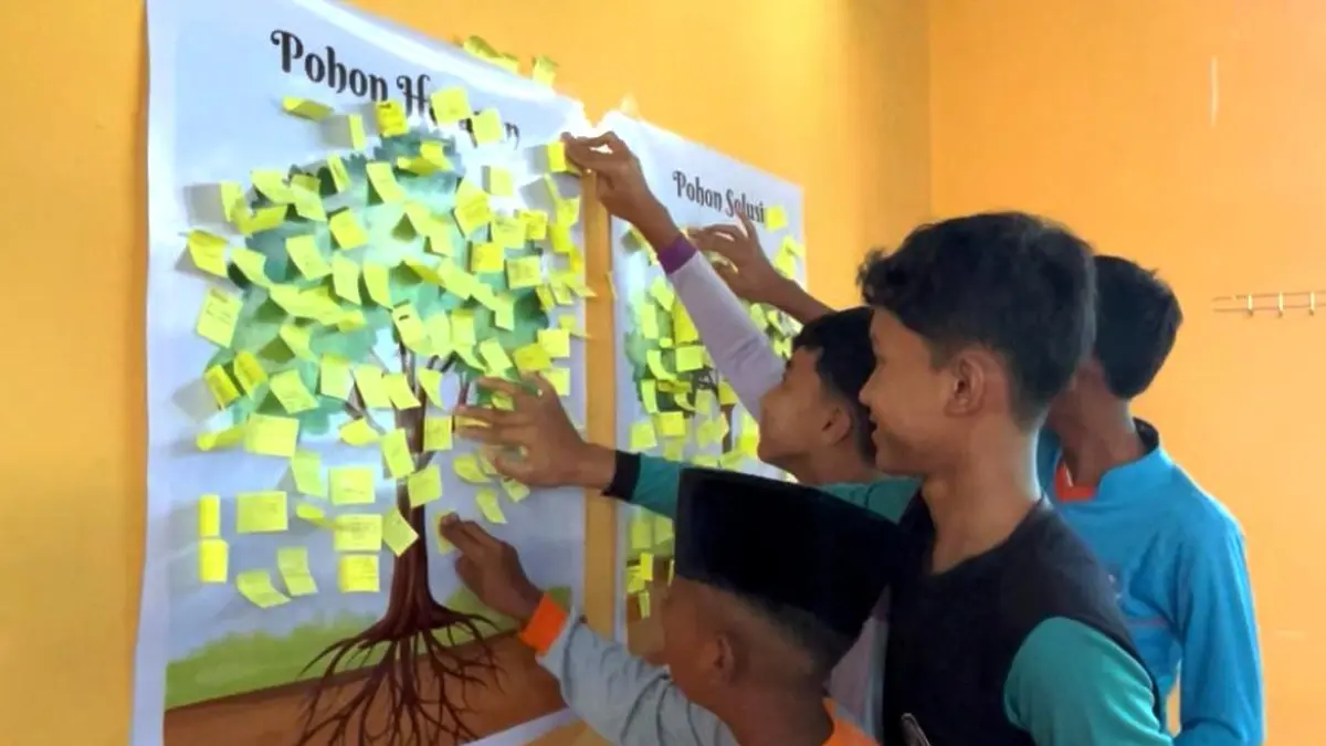 BERANI BERSUARA: Siswa baru SMPN 2 Dawarblandong menempelkan kertas harapan pada media Pohon Harapan dan Pohon Solusi saat kegiatan MPLS, Senin (13/7). 