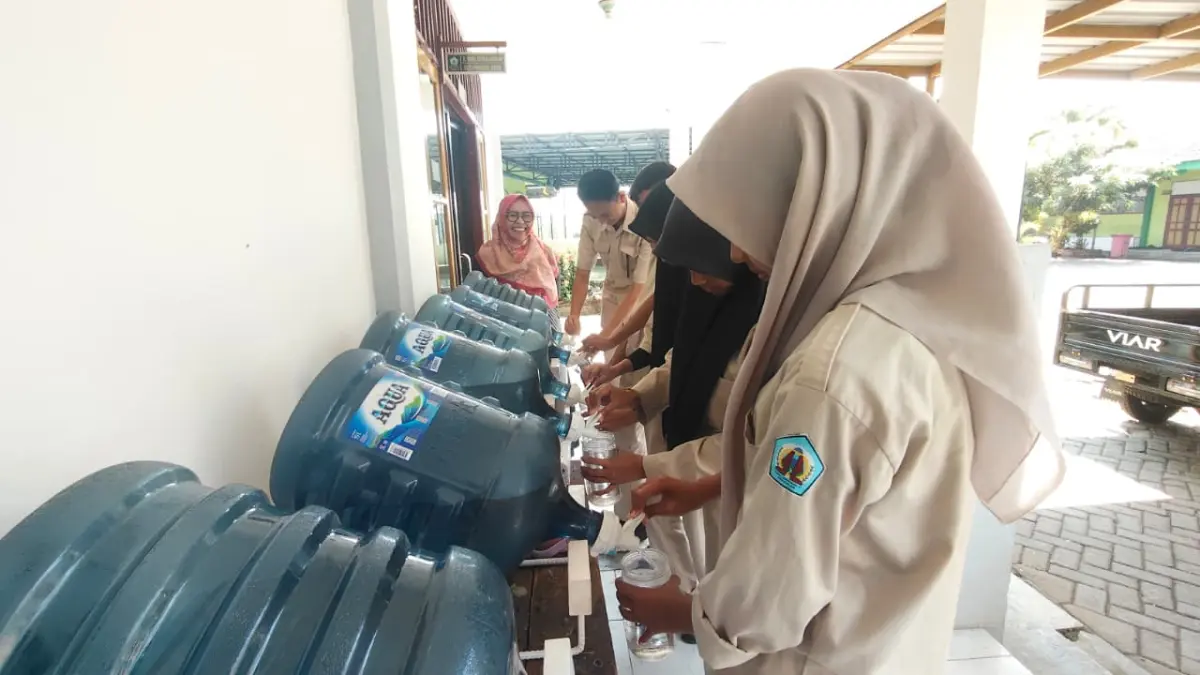 SEKOLAH SEHAT: Peserta didik SMKN 1 Trowulan membiasakan diri mengisi tumbler di galon air minum terpusat yang disediakan sekolah.