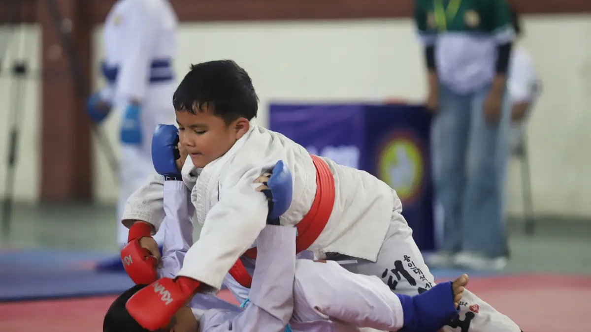MENGGEMASKAN: Dua atlet jujitsu junior saat berlaga di Kejuaraan Jujitsu Wali Kota Cup Tingkat Nasional tahun 2026 di GOR Mojopahit, Kota Mojokerto, Jumat (24/7). (Sofan Kurniawan/JPRM)