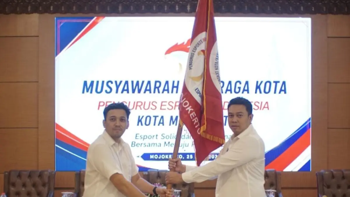 KETUA BARU: Plt Ketua Esport Indonesia Kota Mojokerto Andhis Aries Bagus Kristantyo (kiri) menyerahkan bendera Esports Indonesia Kota Mojokerto kepada Eko Ari Kriswantoro selaku Ketua Terpilih, dalam Musyawarah Olahraga Kota, di Aula Dikbud Kota Mojokerto, Sabtu (25/7). (Arief Hikmawan/JPRM)
