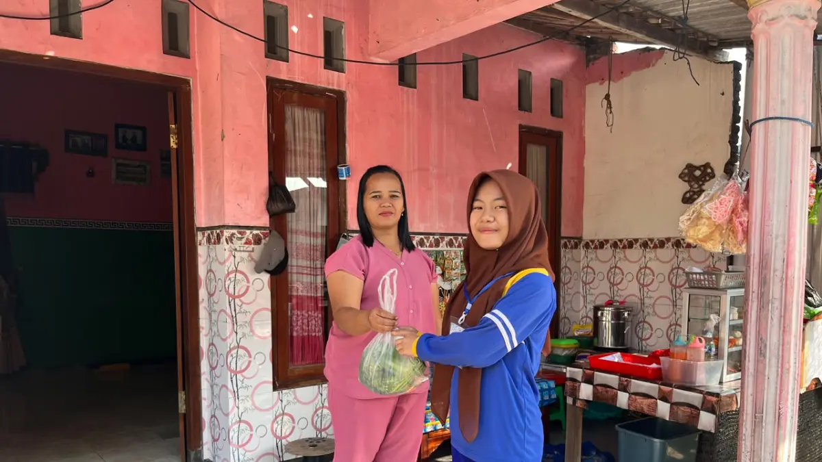 BERBAGI: Siswa SMPN 1 Pungging membagikan sayur kepada warga yang tinggal di sekitar sekolah.