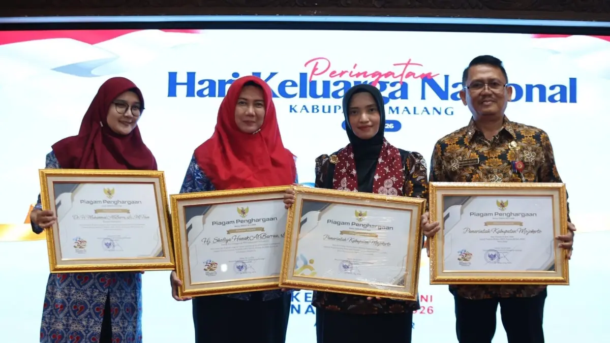 BUAH KOMITMEN: Istri Wabup dr Amelia Fitri mewakili Ketua TP PKK Kabupaten Mojokerto dan Kepala Dinas P2KBP2 Bambang Wahyuadi mewakili Bupati Mojokerto menerima berbagai penghargaan di Peringatan Harganas ke-33 di Pendopo Agung, Kabupaten Malang, Rabu (29/7).