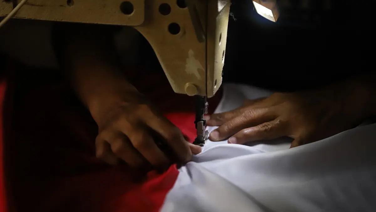 BERKAH KEMERDEKAAN: Perajin bendera merah putih di Lingkungan Balongsari Gang 5, Kelurahan Balongsari, Kecamatan Magersari, Kota Mojokerto, mengerjakan pesanan, kemarin (30/7). (Sofan JPRM)