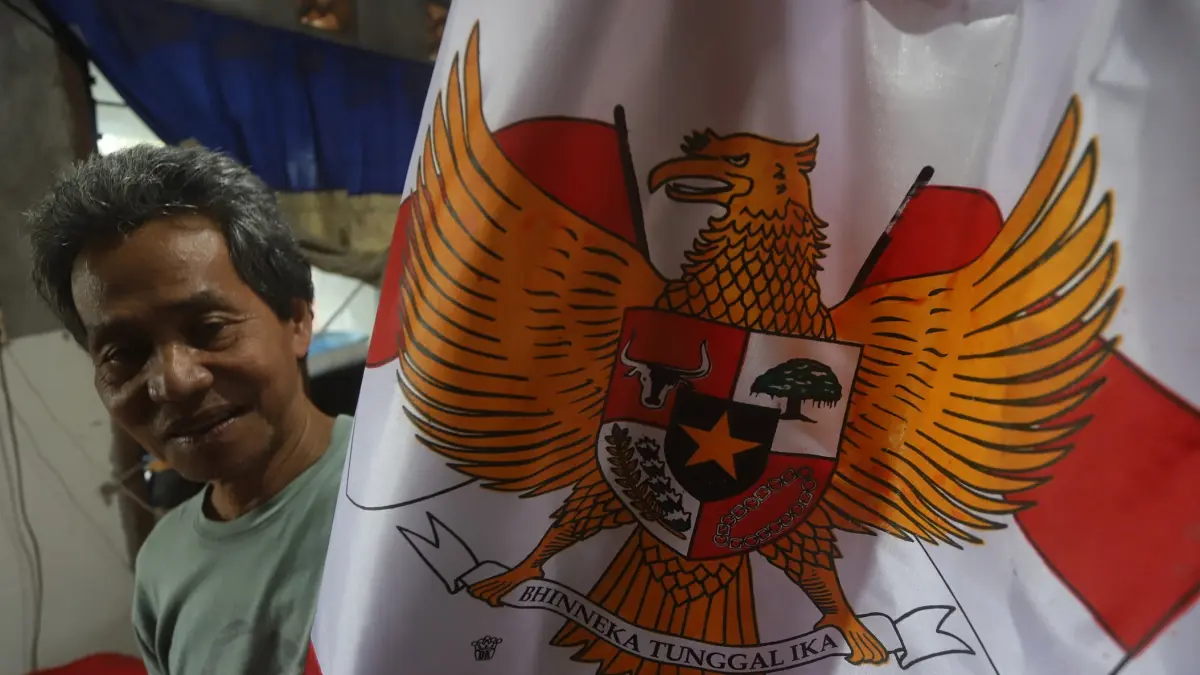 KONSISTEN: Suboko menunjukkan hasil karya kerajinan bendera merah putih di rumahnya di Lingkungan Balongsari Gang 5, Kelurahan Balongsari, Kecamatan Magersari, kemarin (30/7). Selain bendera, ia juga melayani pesanan umbul-umbul berbagai jenis ukuran.