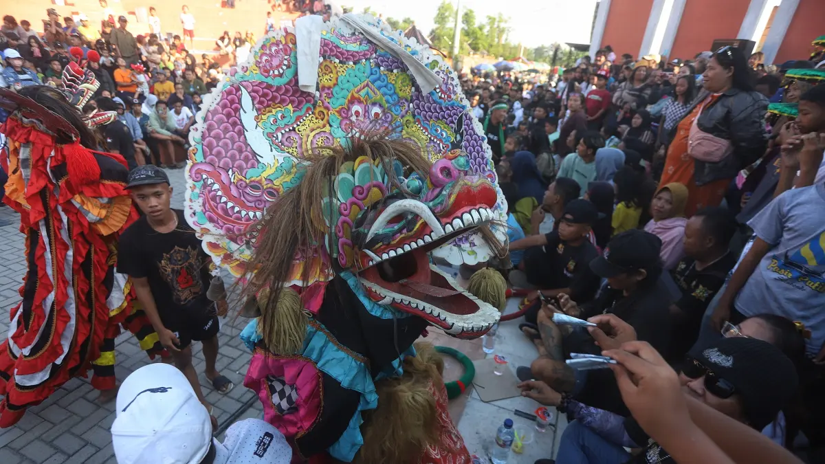 RAMAI: Penyaji seni barongan mengambil saweran dari penonton. Mereka pentas di kawasan Taman Bahari Mojopahit (TBM), Kecamatan Prajurit Kulon, Kota Mojokerto, Minggu (26/7). (Sofan JPRM)