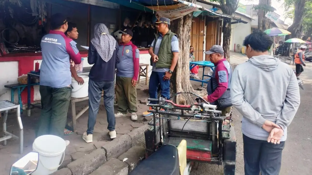 DIDATA: Personel Satpol PP bersama paguyuban PKL melakukan verifikasi dan validasi pedagang yang membuka lapak di sepanjang Jalan Niaga, Kecamatan Mojosari, Jumat (24/7) lalu. (Rizal JPRM)