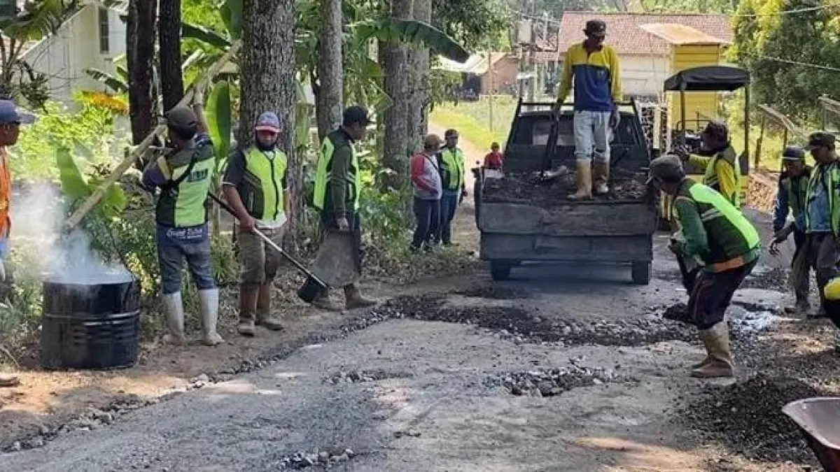 DIREHABILITASI: Tim pekerja dari Dinas PUPR Kabupaten Mojokerto melakukan perbaikan jalan rusak di Dusun Pacet Selatan, Desa/Kecamatan Pacet, kemarin (2/8). (Rizal JPRM)