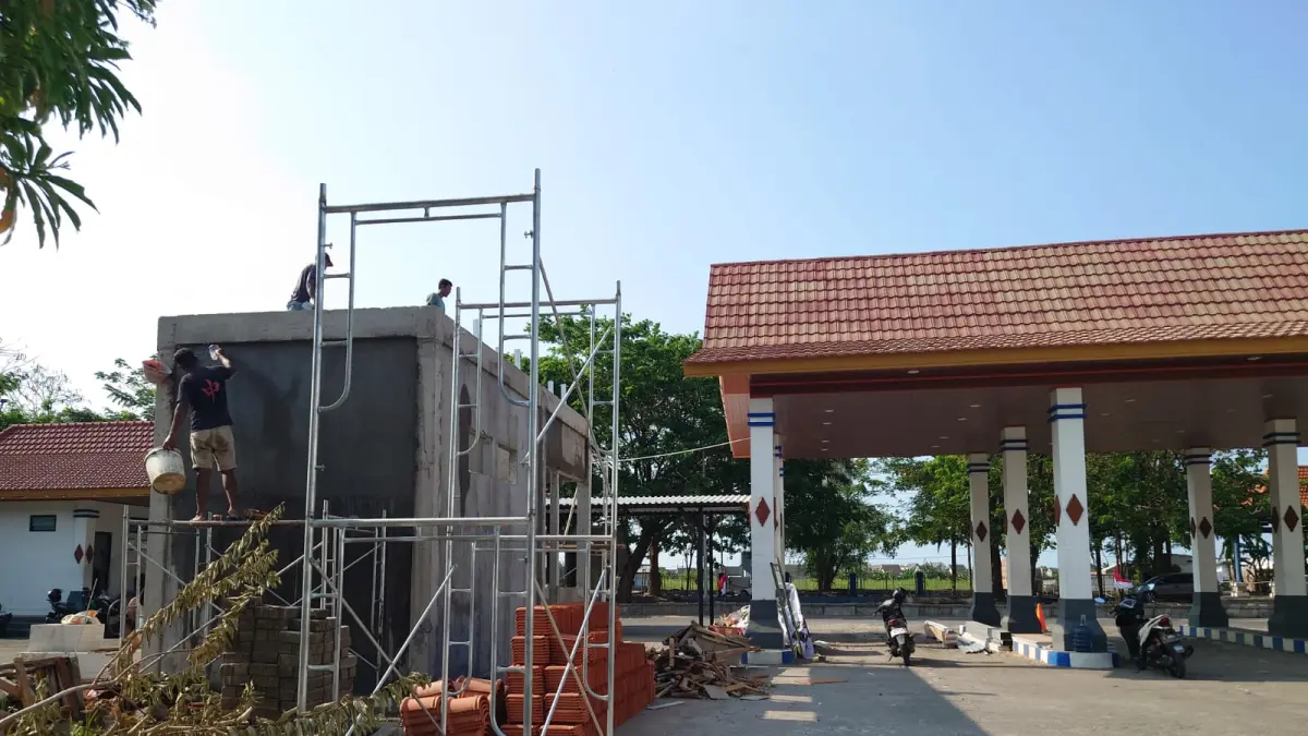 DITAMBAH: Pekerja sedang melaksanakan pembangunan prasarana yang sedianya akan dijadikan sebagai pos pendataan kendaraan umum di Terminal Mojosari, Senin (3/8). (Rizal JPRM)