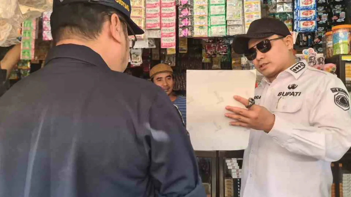 GEMPUR ROKOK ILEGAL: Bupati Mojokerto Muhammad Albarra bersama Kepala Kantor Bea Cukai Sidoarjo, Rudy Hery Kurniawan dan didampingi Kasatpol PP M. Taufiqurrahman tempel stiker rokok ilegal di pedagang di pasar Sawahan, Desa Sumbertebu, Kecamatan Bangsal, Rabu (5/8).