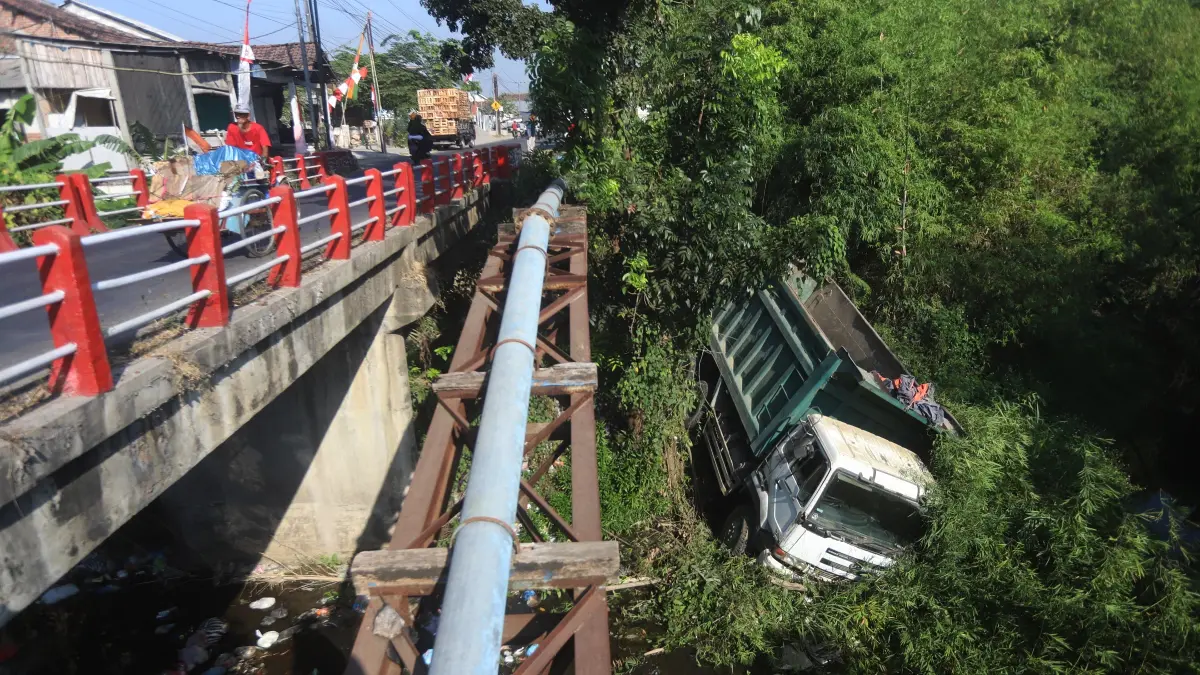 TERJEREMBAB: Armada dump truk yang disopiri Marwan nyungsep di dasar Sungai Desa Bendung, Kecamatan Jetis, Kamis (6/8). (Sofan JPRM)