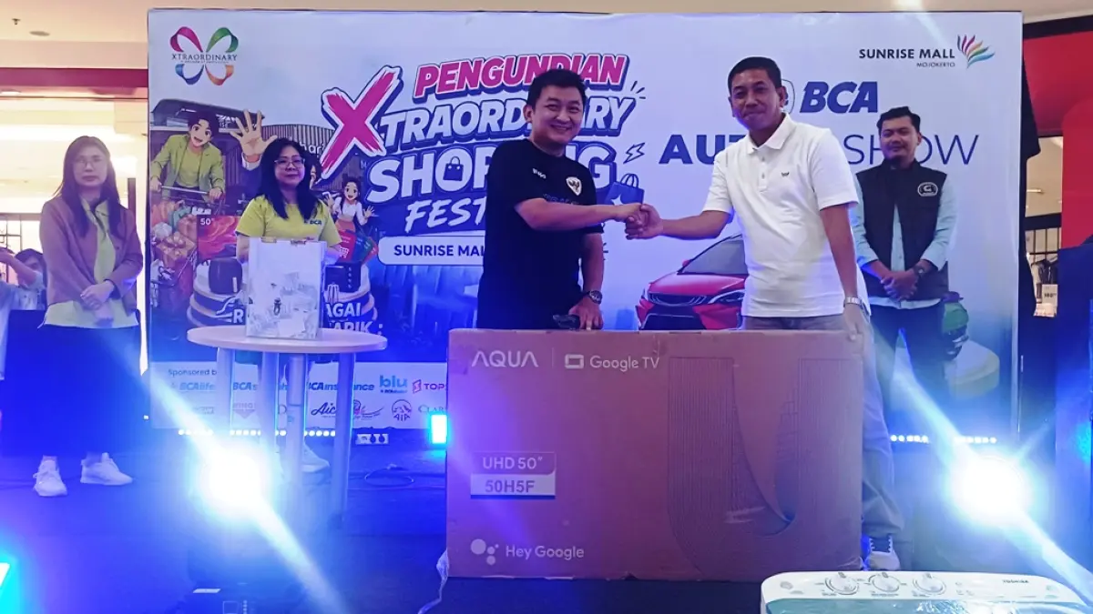SIMBOLIS: Kepala BCA KCU Mojokerto, Michael Bastian secara simbolis menyerahkan hadiah utama TV LED 50 inch kepada Chief Engineering Sunrise Mall Mojokerto, Bambang Siswanto.