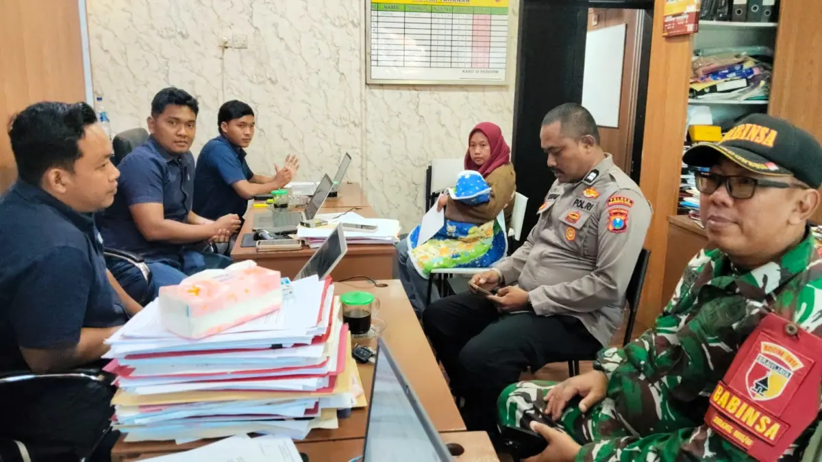 DILAPORKAN: Novia Sari (tiga dari kanan) didampingi Bhabinkamtibmas dan Babinsa Desa Mojowiryo saat membuat laporan ke Satreskrim Polres Mojokerto Kota, Rabu (12/8).&nbsp;(Martda JPRM)