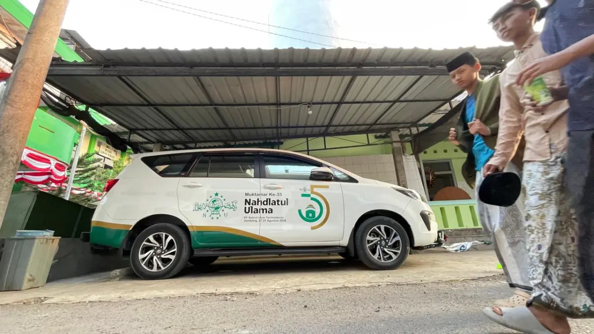 TUAN RUMAH:&nbsp;Santri Pondok Pesantren Bahrul Ulum Tambakberas, Jombang melintas di depan mobil Toyota Innova berlogo Muktamar ke-35 NU.