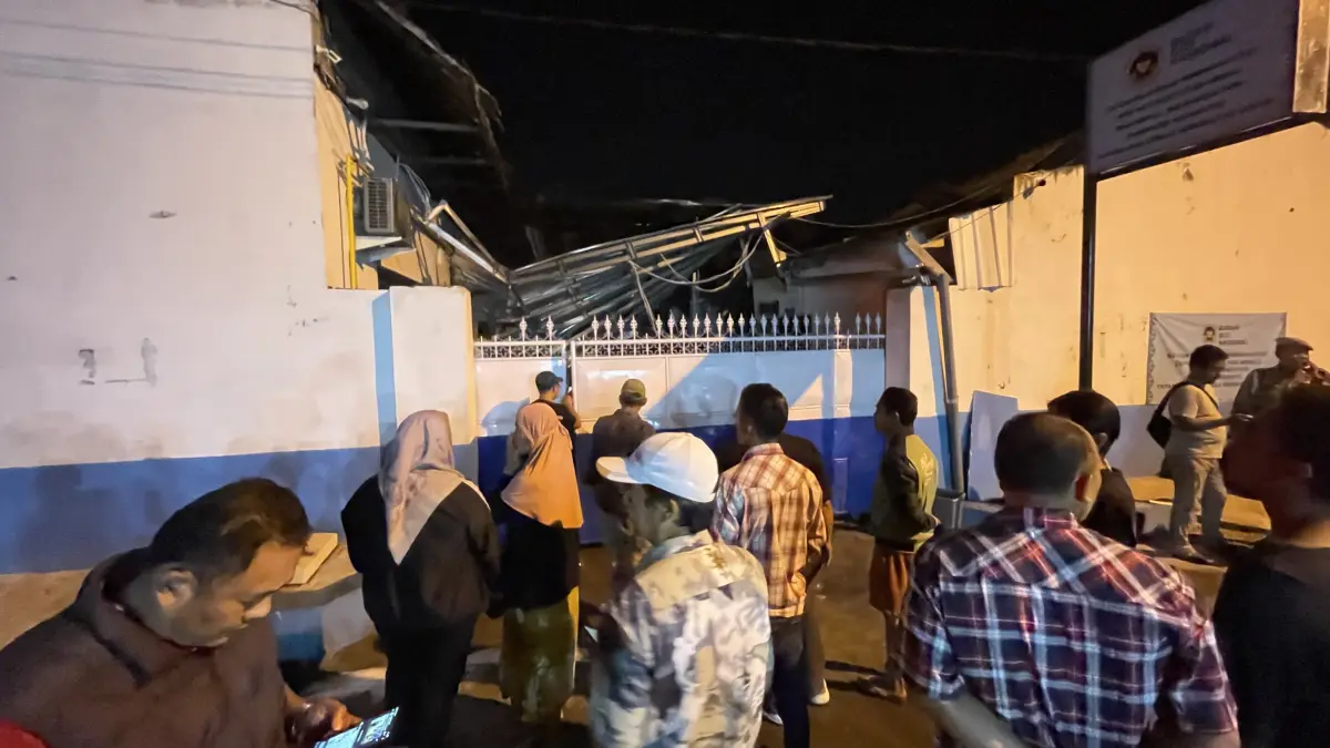 AMBRUK: Warga melihat kondisi SPPG Medali 1, Desa Medali, Kecamatan Puri, Kabupaten Mojokerto yang meledak dan terbakar, Kamis (13/8) malam.