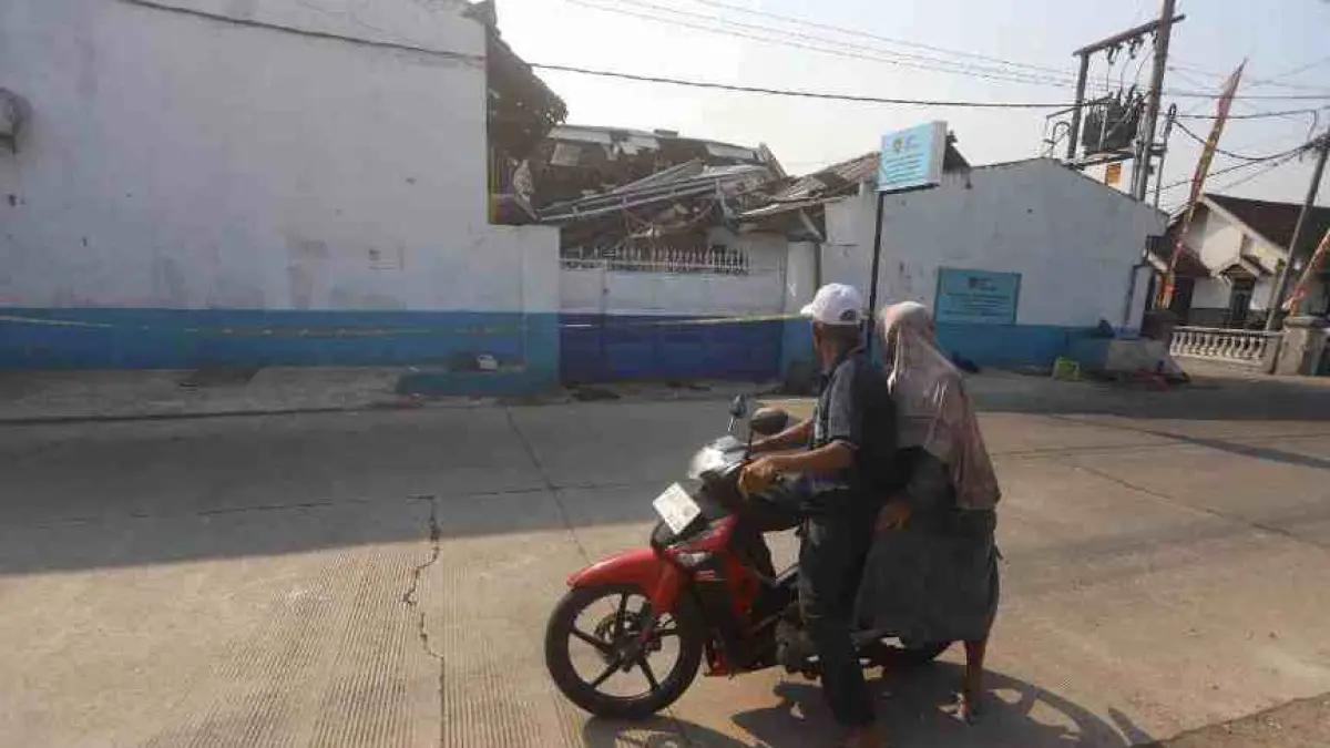 KEJADIAN LUAR BIASA: Pengguna jalan berhenti persis di depan SPPG Medali 1 yang meledak dan terbakar pada Kamis (13/8) malam. (Sofan Kurniawan/JPRM)