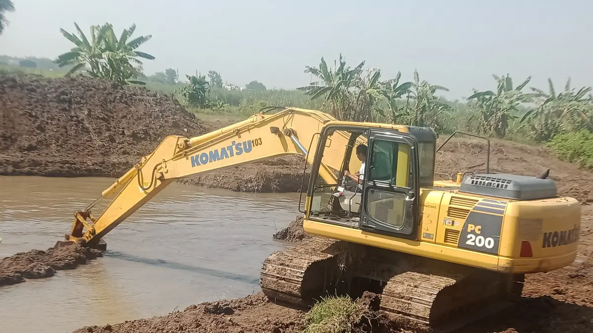 TERJUNKAN ALAT BERAT: Dinas PUPR Kabupaten Mojokerto melakukan normalisasi aliran irigasi di Desa Watesumpak, Kecamatan Trowulan untuk perkuat infrastruktur pertanian, Jumat (14/8). (Dori JPRM)