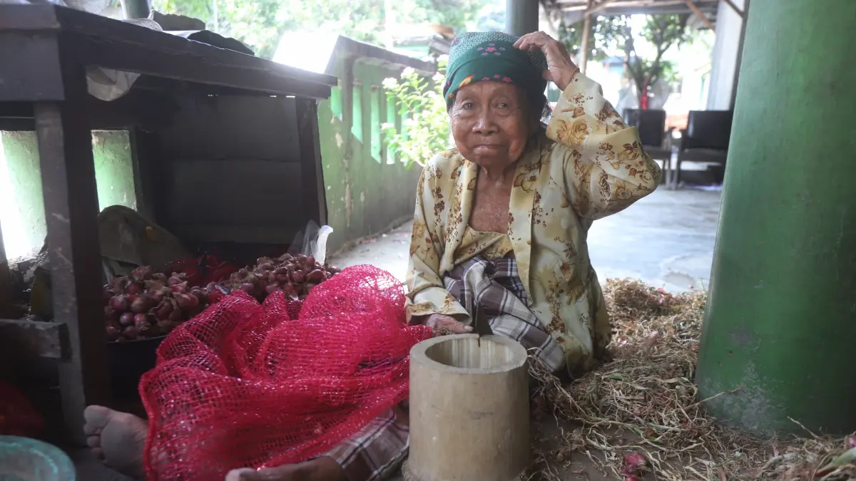 AKTIVITAS: Watiah, 65, mengaku hanya mendapatkan upah Rp 500 untuk setiap kilogram bawang yang ia kupas. (Sofan Kurniawan/JPRM)