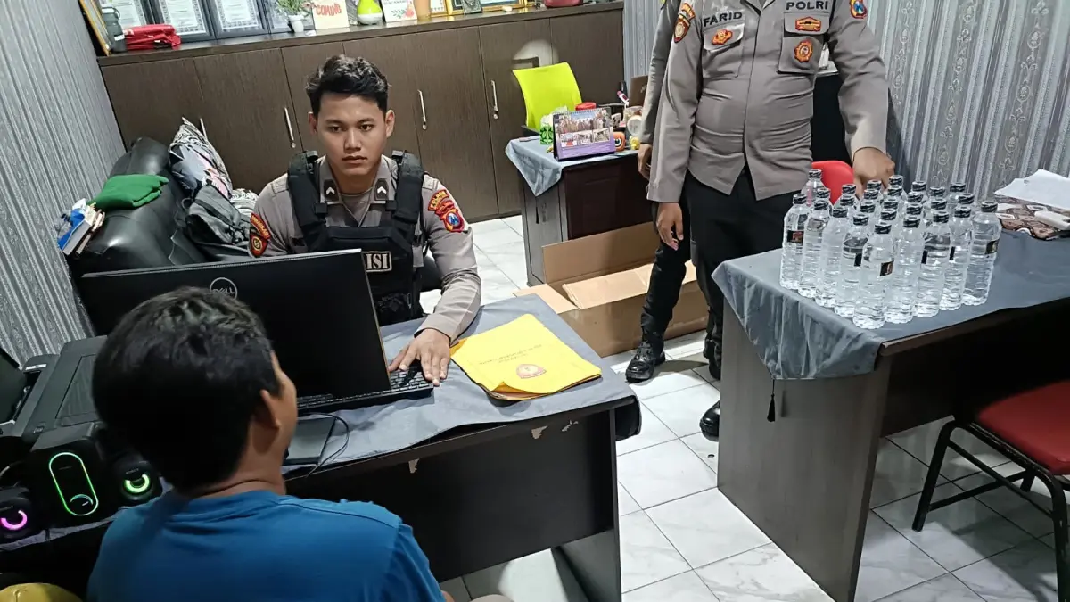 DITINDAK: Petugas Satsamapta saat memeriksa OWP, penjual miras ilegal di Mapolres Mojokerto Kota, baru-baru ini. (dok JPRM)