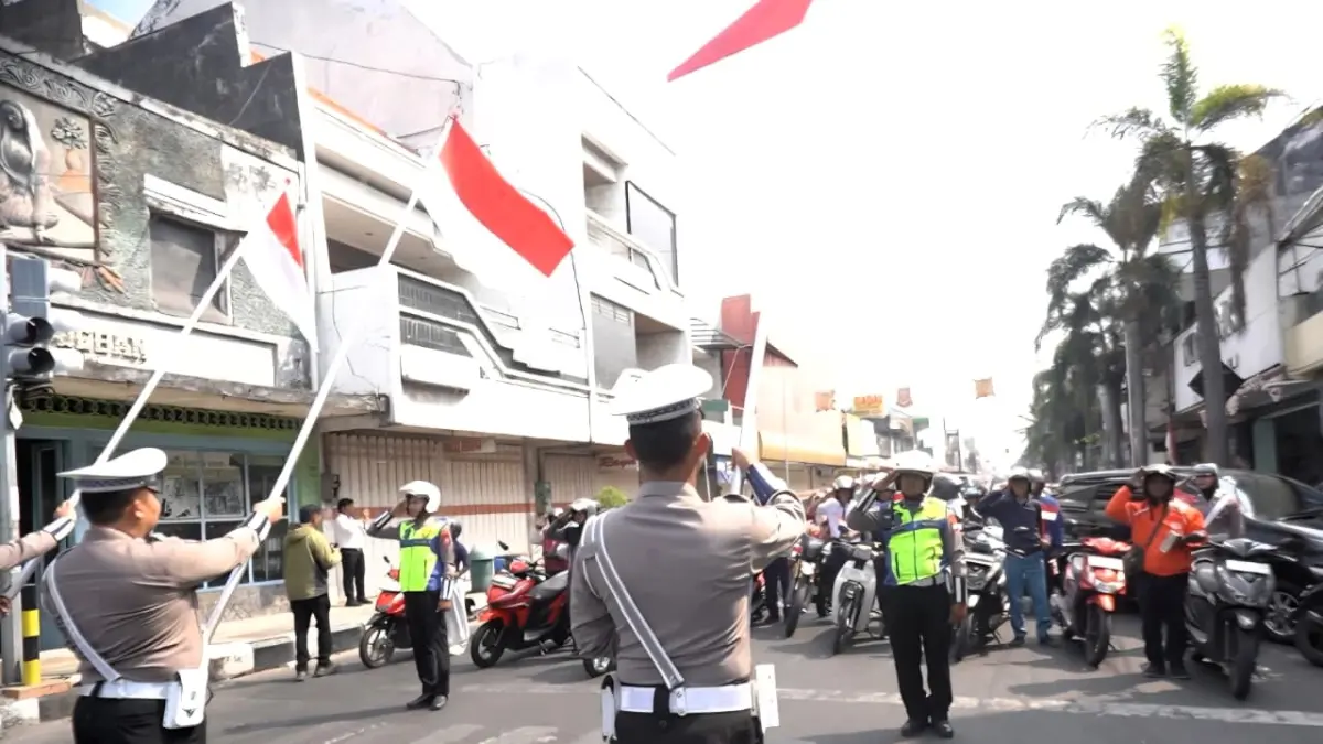 SEMANGAT KEBANGSAAN: Seluruh pengguna jalan di simpang empat Jalan Mojopahit, Kelurahan Miji, Kecamatan Kranggan memberikan penghormatan pada bendera merah putih dalam rangka HUT ke-81 Kemerdekaan RI, Senin (17/8). 