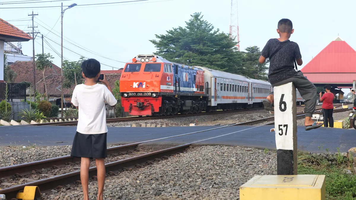 AKTIVITAS BERESIKO: Kereta api melintas di jalur ganda Kota Mojokerto kawasan Jalan Mojopahit, Jumat (21/8). Kondisi itu terbilang berisiko lantaran jarak dengan perlintasan kereta terbilang amat dekat. (Sofan Kurniawan/JPRM)