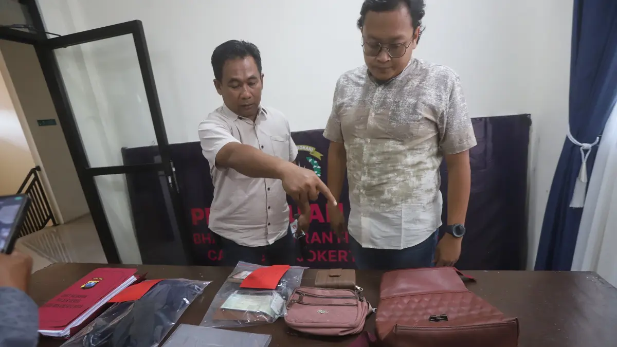 PERAMPASAN: Kanit Reskrim Polsek Gedeg Abus Sadikin memenunjukkan barang bukti milik korban di mapolsek, Jumat (21/8). (Sofan Kurniawan/JPRM)