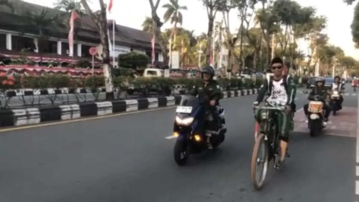 MENUJU KOTA SANTRI: Wildan mengayuh sepeda ontel menuju Pelabuhan Semayang Balikpapan, Kalimantan Timur, dengan dikawal anggota Banser, Minggu (23/8).