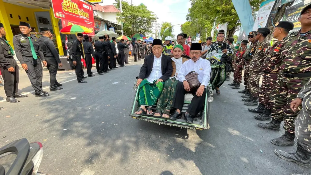 BERSARUNG: Pengasuh Pondok Pesantren KH Asep Saifuddin Chalim naik becak listrik menuju lokasi pembukaan muktamar.