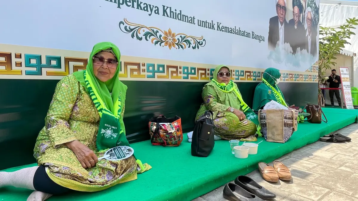 KLESETAN: Rombongan PC Muslimat NU Pangandaran, Jawa Barat, mengikuti acara pembukaan muktamar di bawah photobooth berukuran besar.