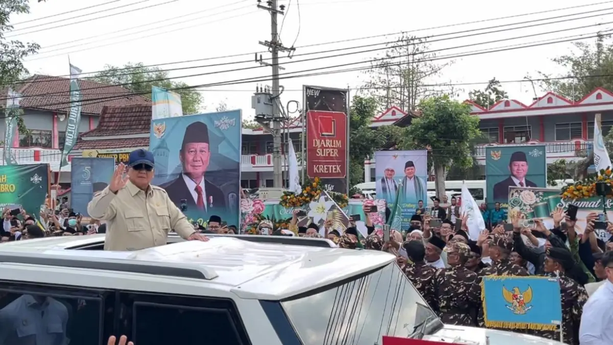 MENYAPA NAHDLIYIN: Presiden RI Prabowo Subianto melambaikan tangan kepada warga NU sebelum memasuki lokasi pembukaan Muktamar ke-35 NU, di Lapangan Untung Suropati, Tambakberas, Jombang, Kamis (27/8). (Chariris/JPRM)