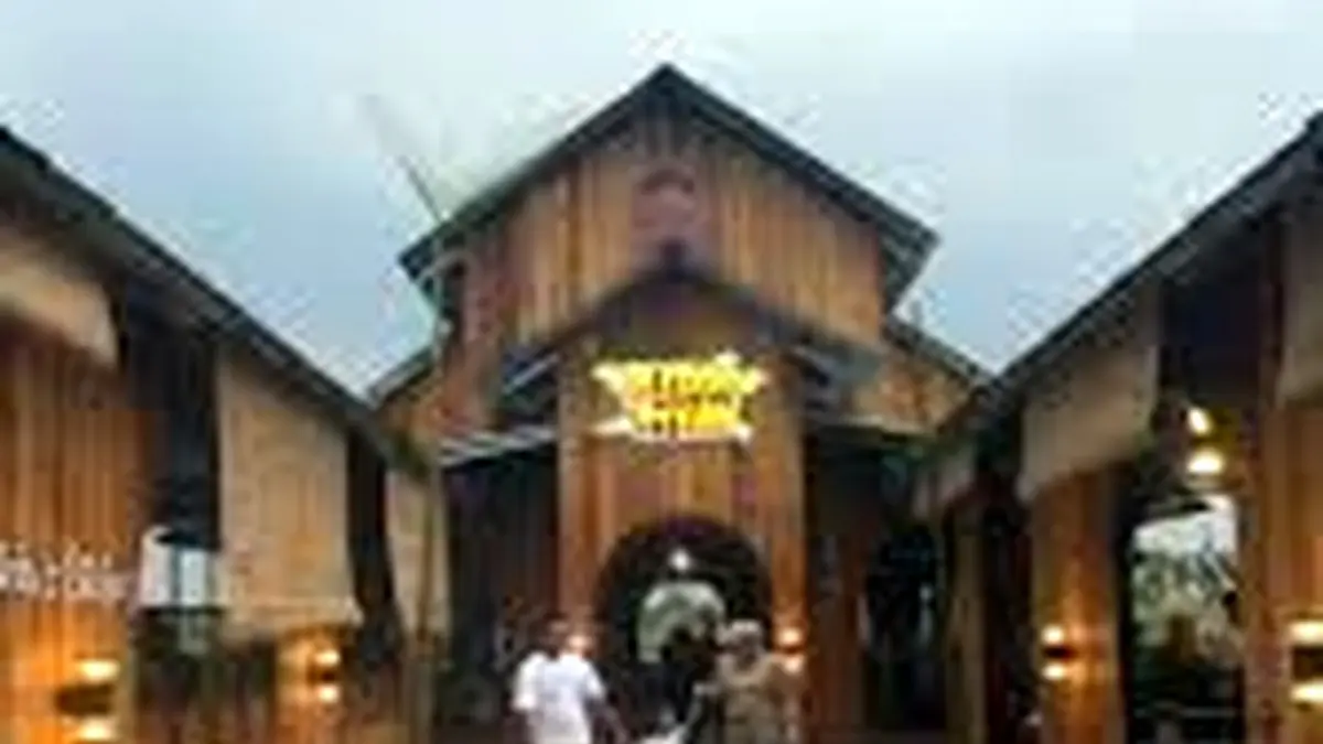 Suasana pengunjung di area pintu masuk tempat kuliner bernuansa kayu.