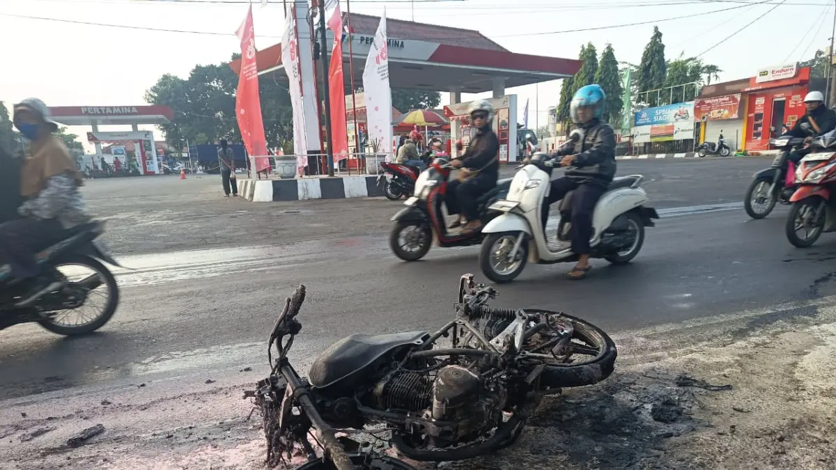 TINGGAL RANGKA: Sepeda motor Suzuki Thunder yang ludes terbakar usai mengisi BBM di SPBU, Jalan Raya Desa Awang-Awang, Kecamatan Mojosari, Kamis (27/8) pagi. (Rizal JPRM)