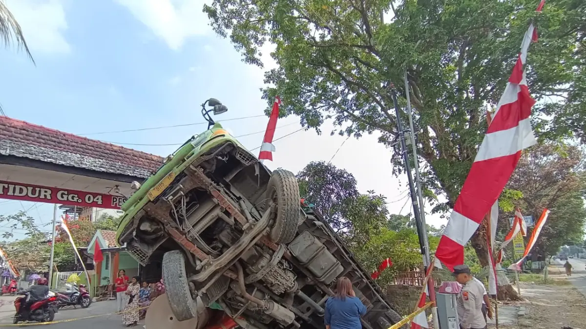HILANG KENDALI: Truk tronton bermuatan bahan karton yang mengalami kecelakaan tunggal di Jalan Raya Desa Pesanggrahan, Kecamatan Kutorejo, Kabupaten Mojokerto, Kamis (27/8). (Rizal JPRM)
